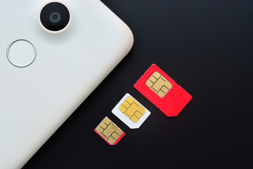 Types of sim cards with smartphone on black background. Mini sim, micro sim and nano sim.