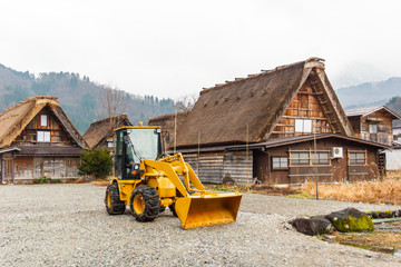 Obraz na płótnie Canvas Bulldozer beside house at Shirakawago.