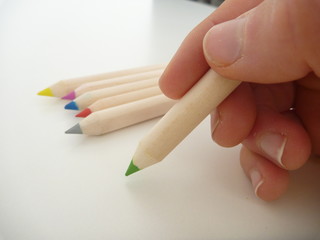 green pencil in a hand writing