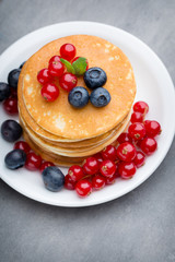 Stack of pancakes with blueberry and fresh berry.