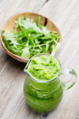 Rucola smoothie, on the grey  background.