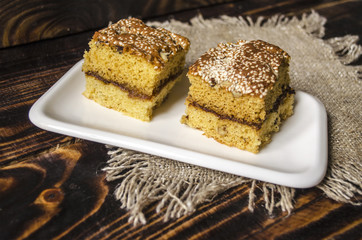 Two slices of sponge cake with nuts and sesame seeds
