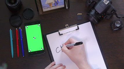 A man writes a pen on paper word creative