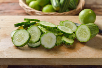 Fresh cucumber and slices on the wooden table