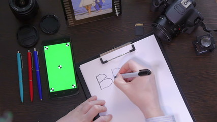 A man writes a pen on paper word brand