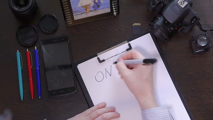 A man writes a pen on paper word online
