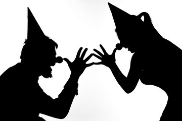 Silhouettes of clowns playing pranks