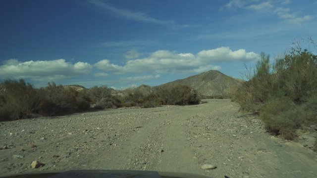 Offroad in Desierto De Tabernas with a Jeep Wrangler, Andalusia, Spain, filmed through the front window with reflections