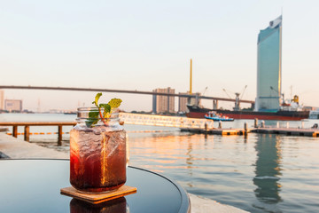 Blueberry soda with blurred river.