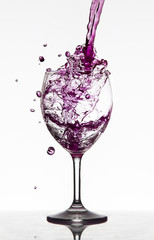 Bicchiere con vino versato che schizza