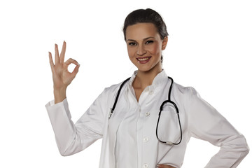 a young woman doctor in uniform showing delicious gesture