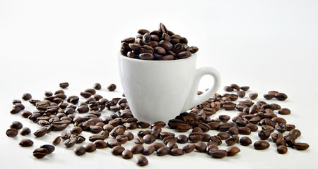 Tazzina con chicchi caffè sparsi