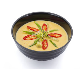 Asian food. Vegetarian coconut soup with corn and tomatoe isolated on white nackground