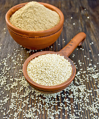 Sesame seeds in ladle on board