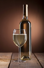 Wineglass and bottle with white wine