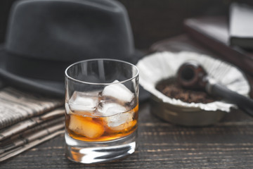 Whiskey with ice , pipe hat and newspaper horizontal
