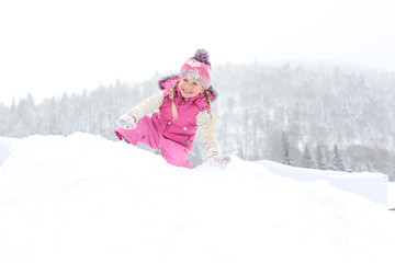 Fototapeta na wymiar little girl happily playing in the snow