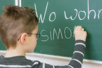 schüler schreibt namen an die tafel