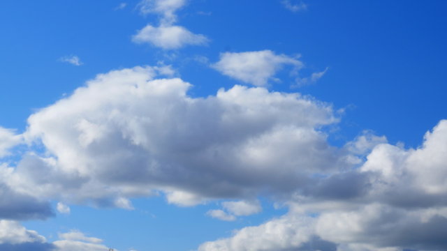 
White cumulus clouds against a blue sky
