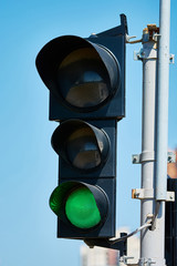 Green color on the traffic light with a beautiful blue sky in ba
