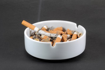 White ceramic ashtray full of smokes cigarettes