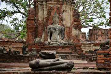 Broken buddha statue and ancient building