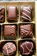 Different types of chocolate candies on a wooden background