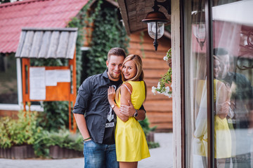 Fototapeta premium Young man and woman on the nature. Playful couple in love. Blonde in a yellow dress and a guy in a T-shirt .