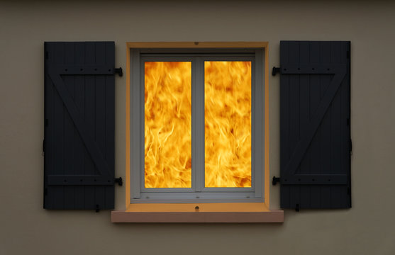 Ausgebrochener Zimmerbrand von au&szlig;en betrachtet durch ein Fenster mit Klappladen