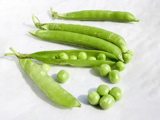 Green Peas and pea fruit the legume on white.