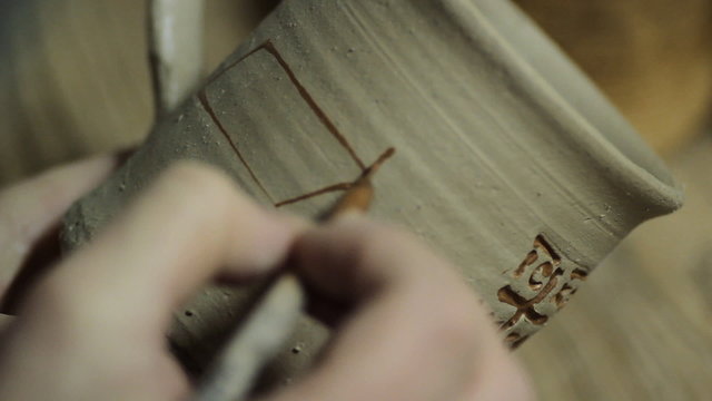 Artist Painting on a Ceramic Plate