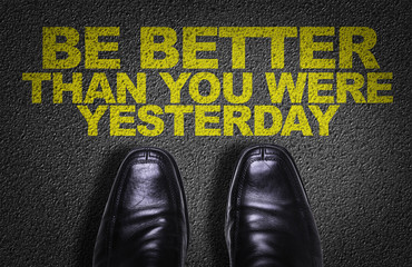 Top View of Business Shoes on the floor with the text: Be Better Than You Were Yesterday