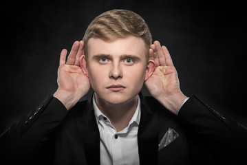 Man listening something over dark background.