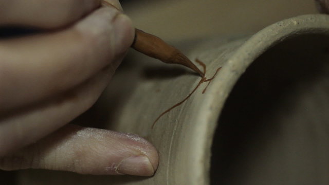 Artist Painting on a Ceramic Plate