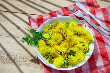 Yellow dandelions on a plate, diet concept