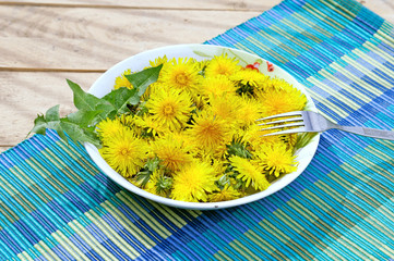Yellow dandelions on plate, healthy food