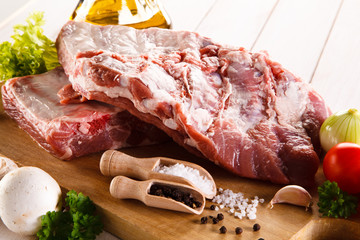 Raw pork ribs on cutting board and vegetables