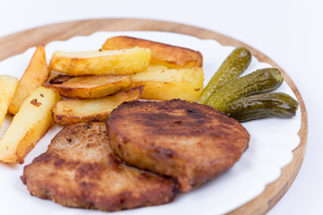 Fresh fried french fries with pork chops and pickled cucumbers