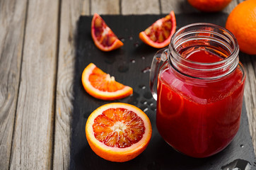 Fresh blood orange juice. Rustic background. Horizontal permission. Selective focus. Copy space.