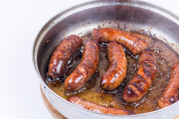 Homemade sausages frying in fat