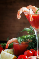 Peeled shrimp with tomato sauce in a martini glass, vegetables a