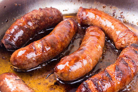 Homemade sausages frying in fat