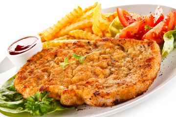 Fried pork chop, French fries and vegetables