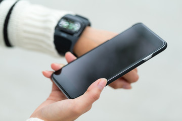 Woman connecting smart watch and cellphone