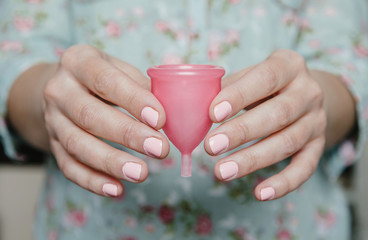Close up of woman hands holding menstrual cup