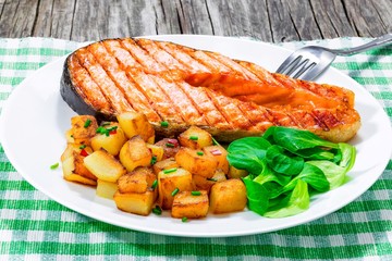 grilled salmon steak with fried potatoes , top view