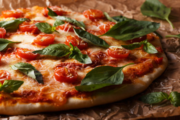 Homemade italian pizza with mozzarella, tomatoes and basil leave