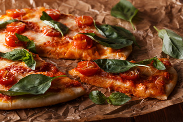 Homemade italian pizza with mozzarella, tomatoes and basil leave