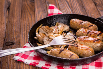 sausage and mushrooms in a frying pan