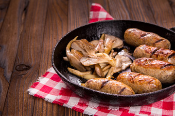 sausage and mushrooms in a frying pan